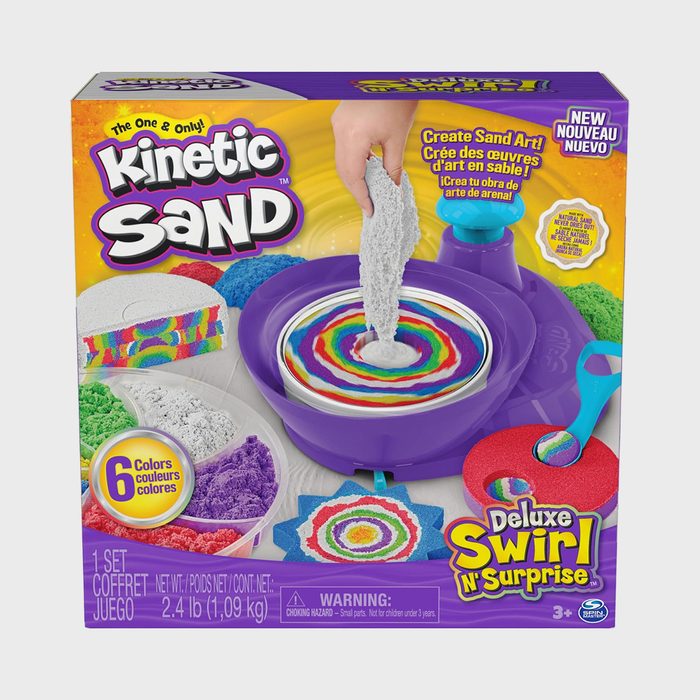 Kinetic Sand toy; hand pouring gray sand into a purple tray surrounded by colorful sand; packaging shows six sand colors and product details.