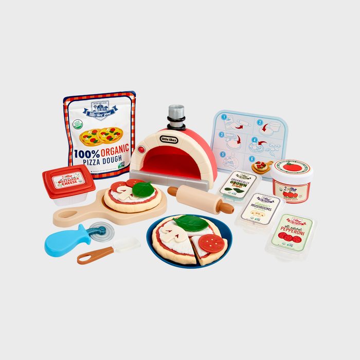 Toy pizza set with oven and ingredients arranged; includes rolling pin, pizza cutter, and packaging. Text: 