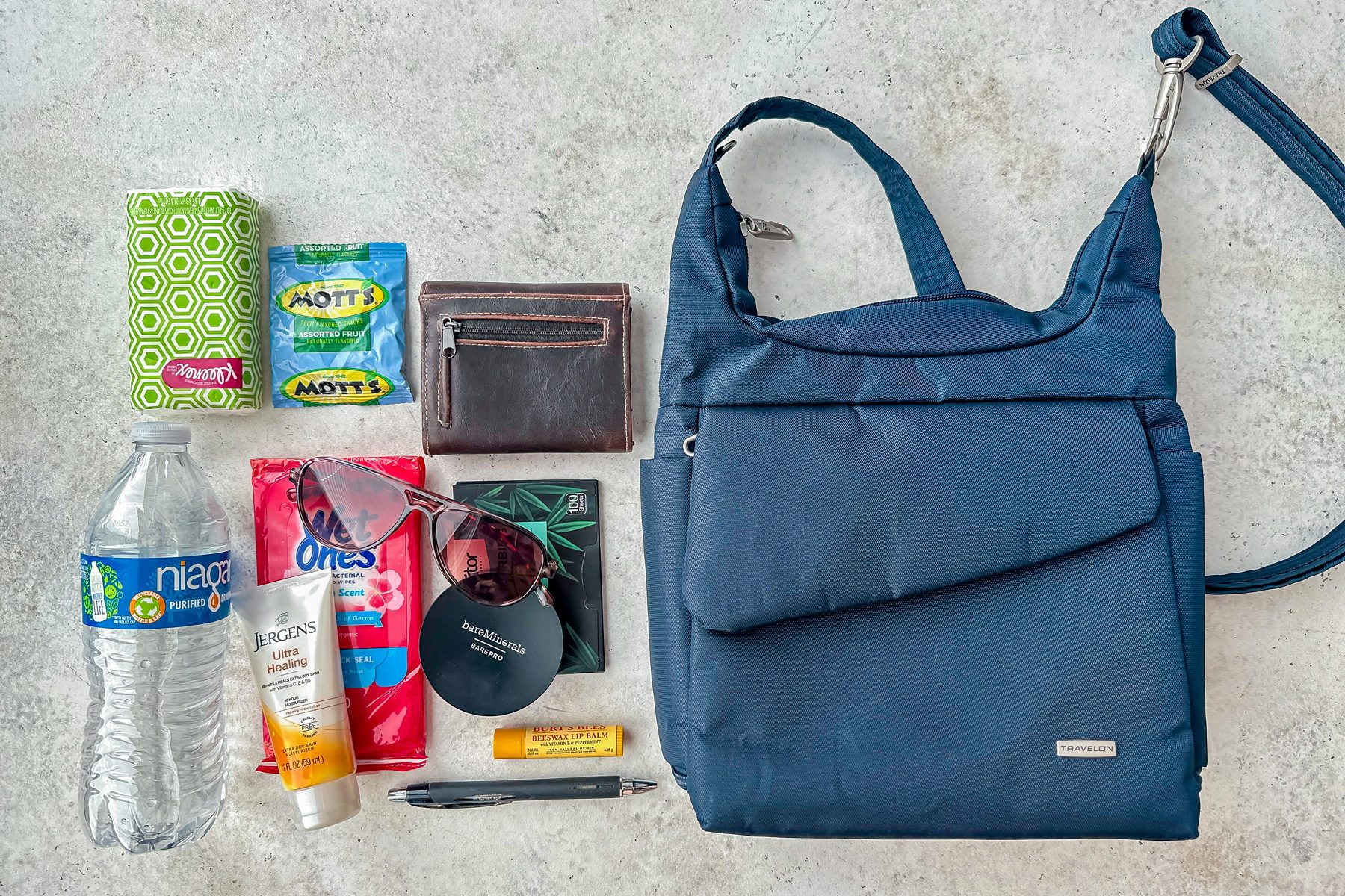 top shot of things kept beside Travelon Anti Theft Classic Messenger Bag