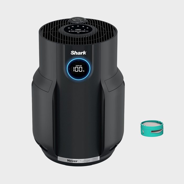 Air purifier displays air quality percentage in a sleek, cylindrical design beside a small, separate circular filter on a neutral background.