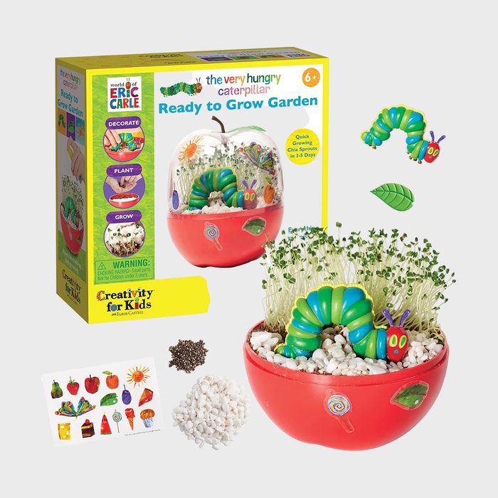 A caterpillar-themed garden kit with a toy caterpillar nestled in sprouting chia seeds inside a red container. Includes seeds, gravel, and stickers.