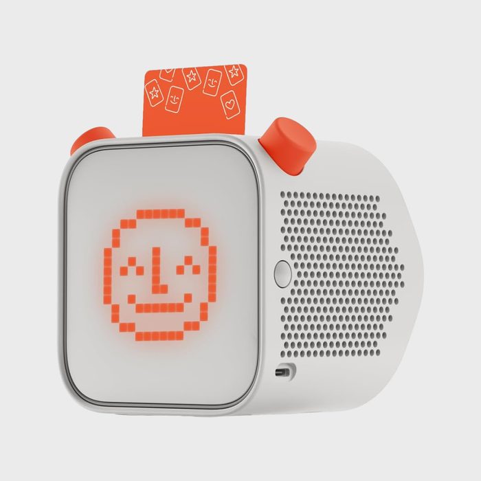Device displays pixelated face on screen, plays sound through speaker; features orange card inserted, red knobs on top.