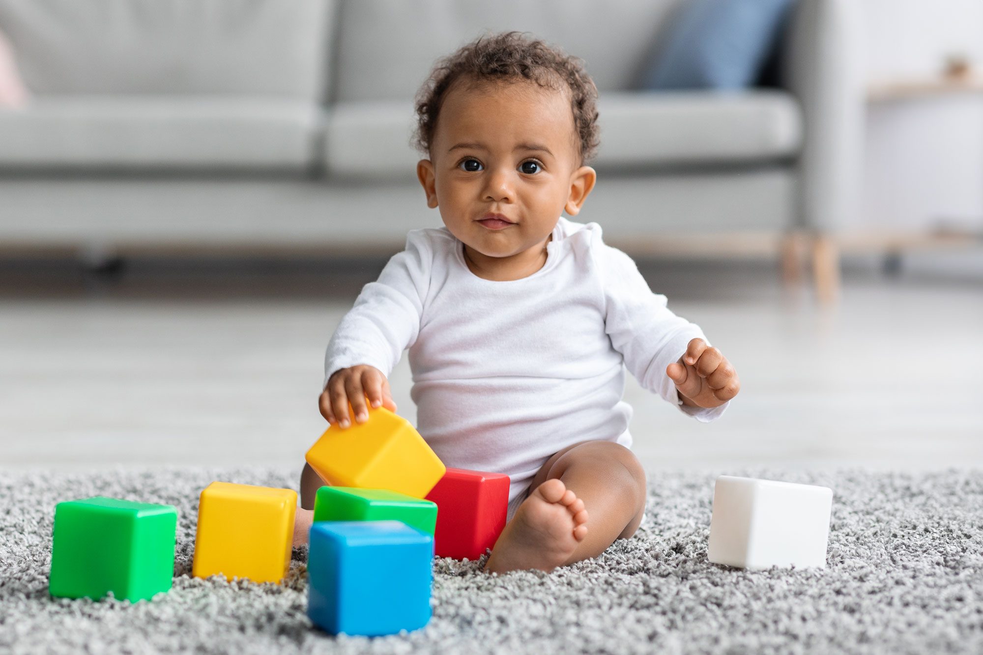 Adorable Black Infant Baby Playing With Stacking Building Blocks At Home