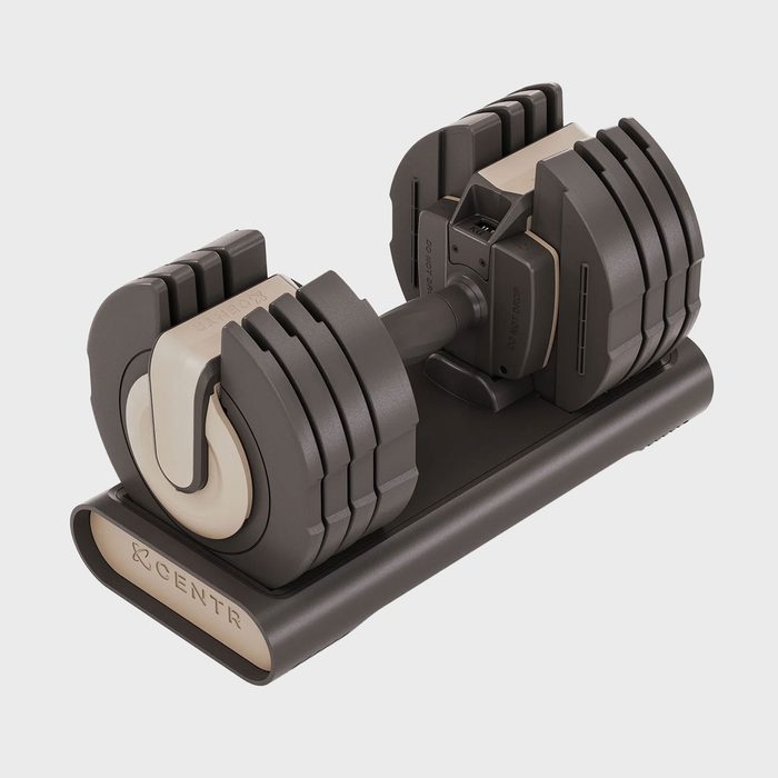 An adjustable dumbbell rests on a stand; 