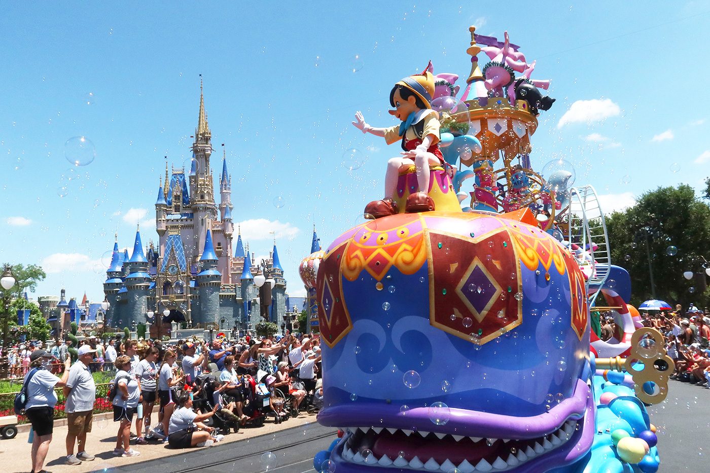 eople watch as the Pinocchio float passes by Cinderella's Castle during the daily Festival of Fantasy Parade at the Magic Kingdom Park at Walt Disney World