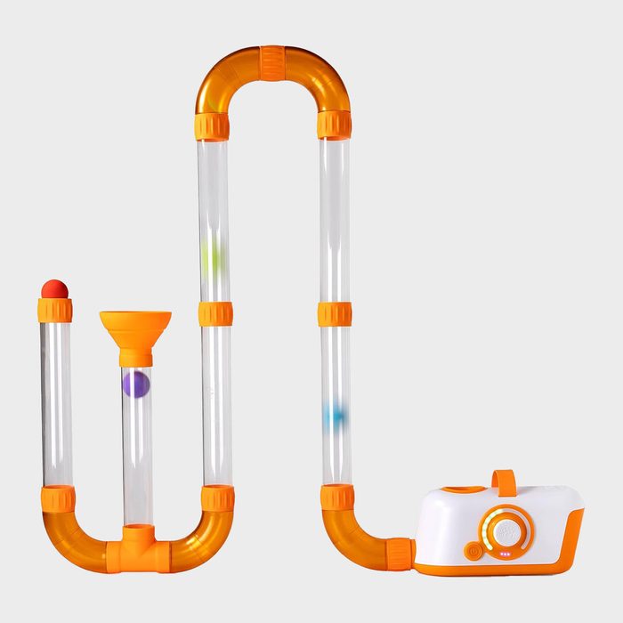 Clear tubes connected by orange joints, guiding colored balls through a funnel, attached to a white and orange base with controls.