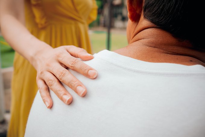 Woman touches a man shoulder