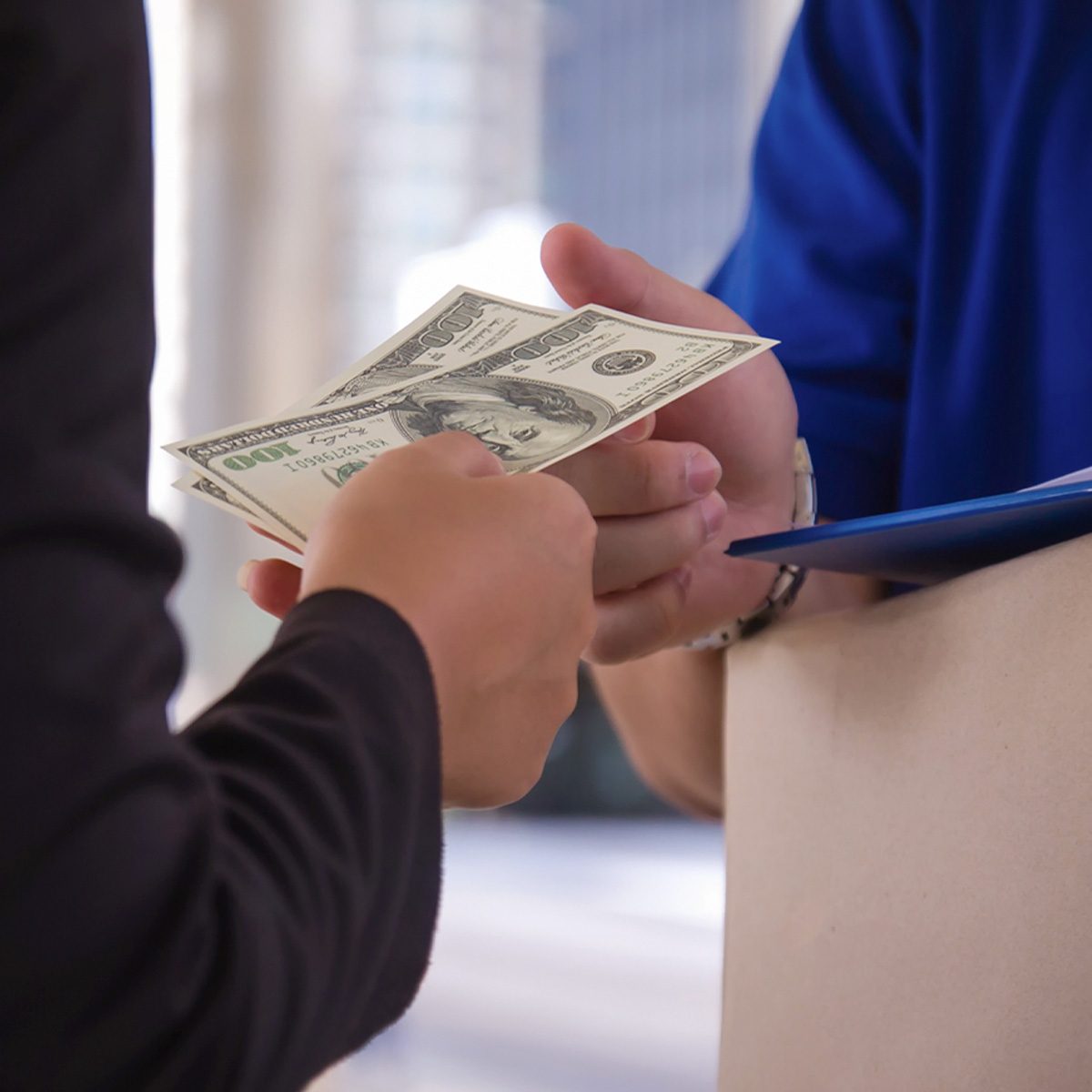 How Much To Tip In Every Situation man paying the mail man via cash