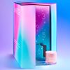 Box opens revealing a beauty product jar; gradient pink and blue background features calendar numbers and decorative stars. Text: 
