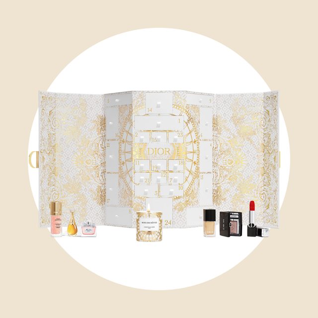 An ornate advent calendar displays small Dior beauty products, including perfumes, a candle, and cosmetics, set against an intricate gold and white design.
