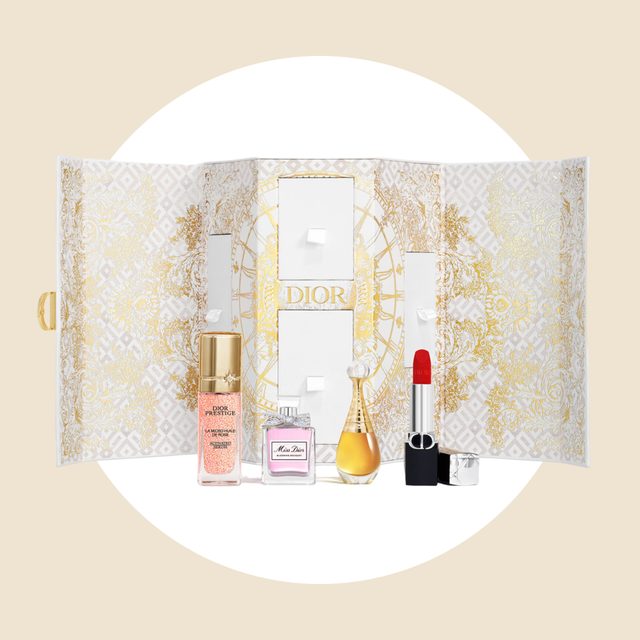 Cosmetic products displayed; Dior branded perfume and makeup arranged against decorative gold-patterned backdrop, featuring an elegant, open presentation box.