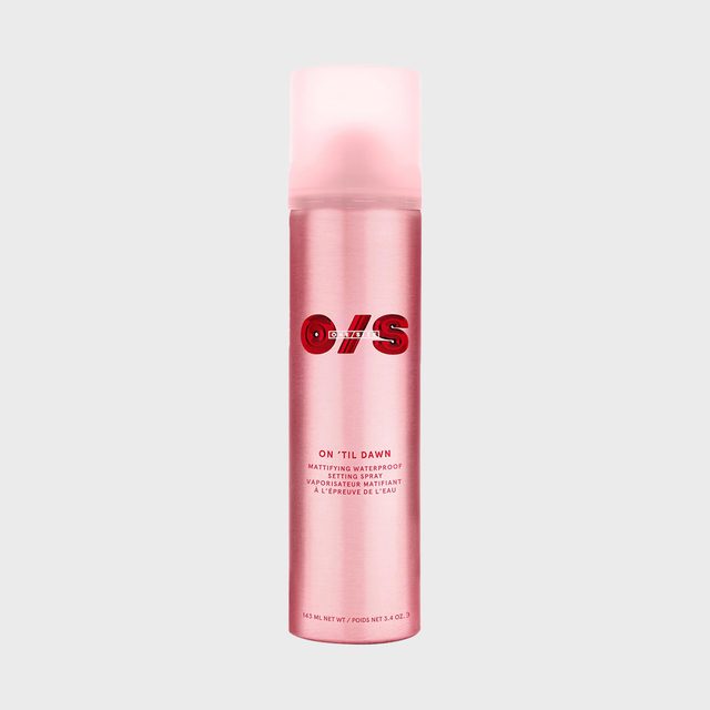 Pink spray bottle stands upright, labeled 