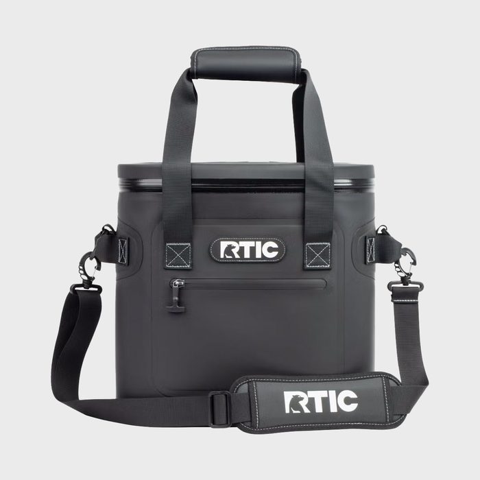 Cooler bag stands upright, featuring black straps and a carrying handle, with 