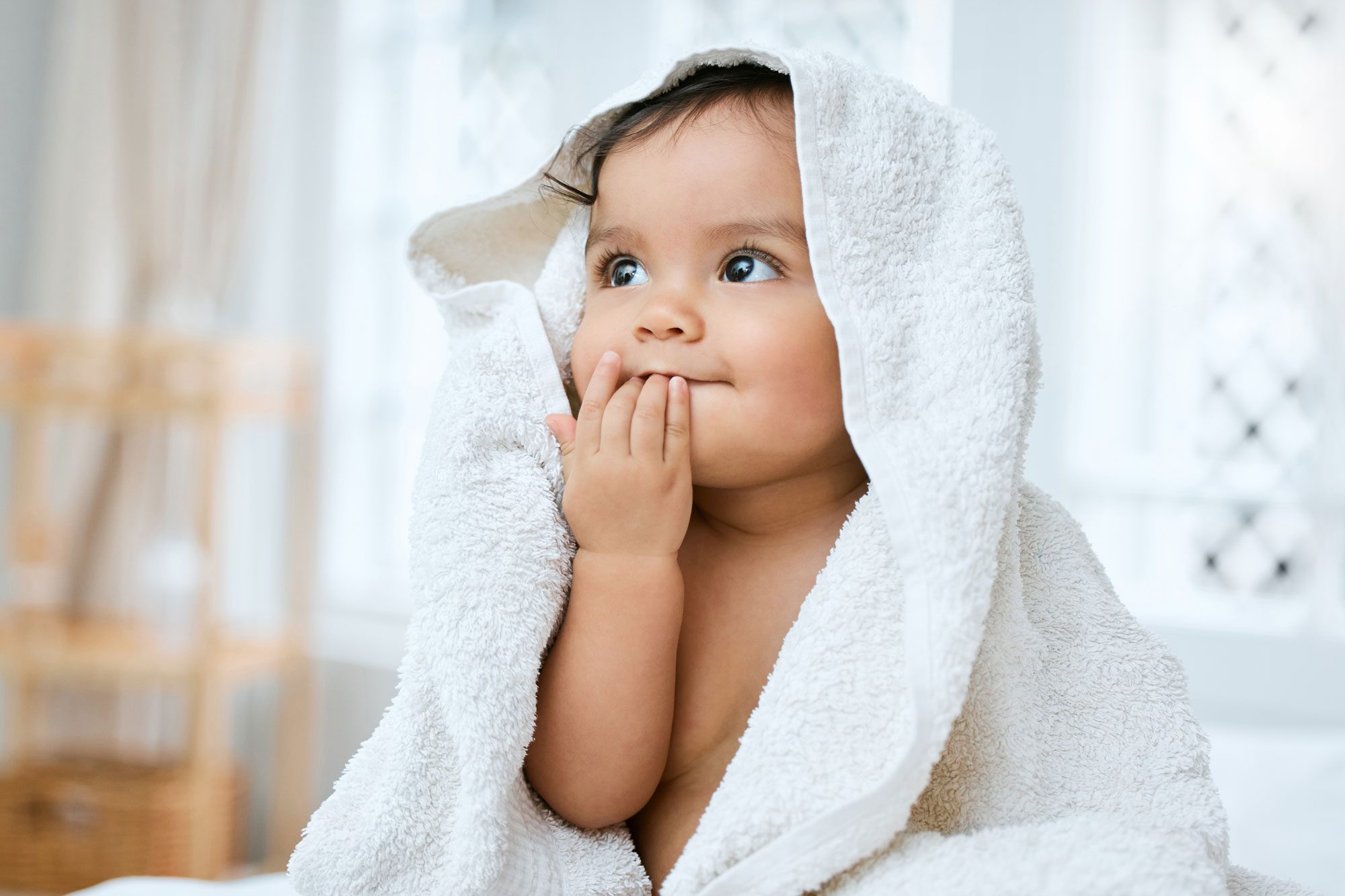 Shot Of An Adorable Baby Covered In A Towel After Bath Time