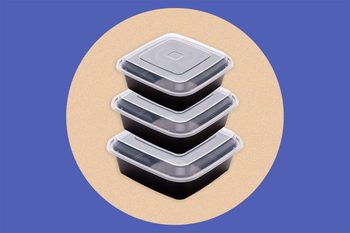 Stacked plastic containers with clear lids, displayed centrally against a circular beige background on a blue surface.
