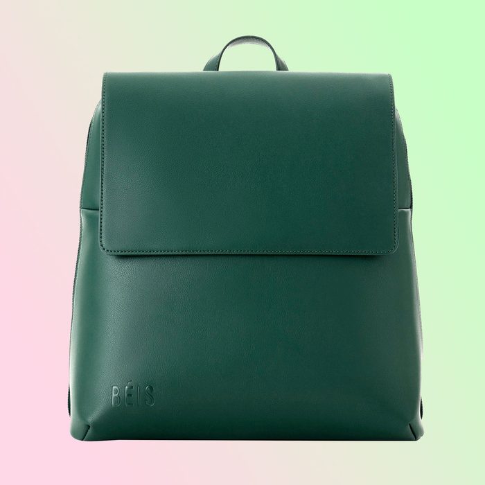 Green backpack displayed against a pastel gradient backdrop. 