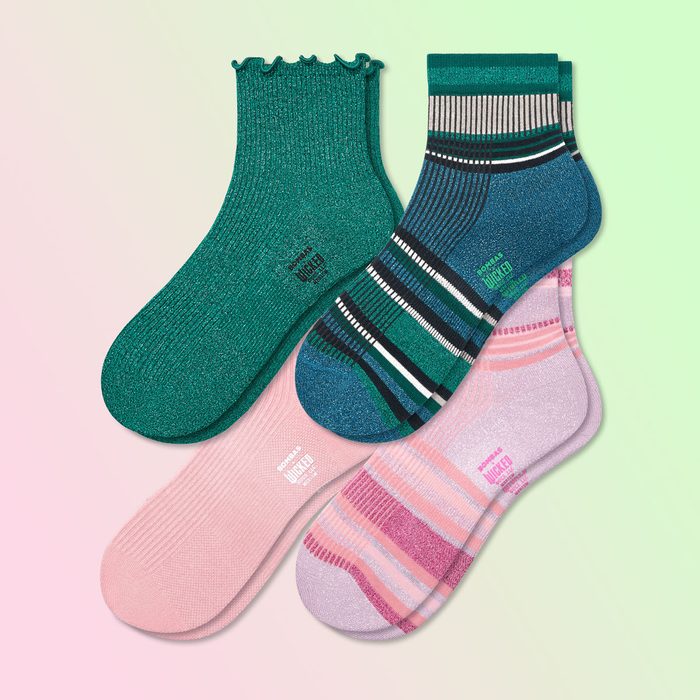 Four colorful socks overlap, displaying solid and striped designs, set on a pastel gradient background. Text reads 