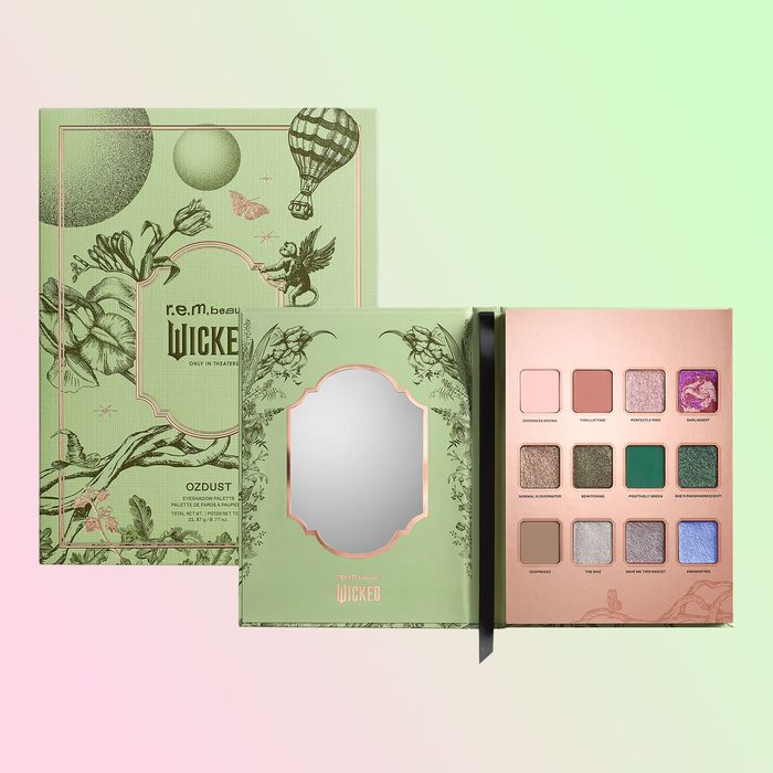 Eyeshadow palette displayed open, showing various shades with a mirror; surrounded by green-themed packaging featuring botanical illustrations and a hot air balloon design.