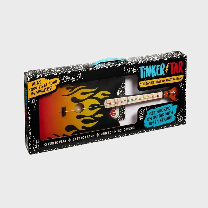 Guitar toy displayed in packaging, features flame design, promises easy learning. Box reads, 