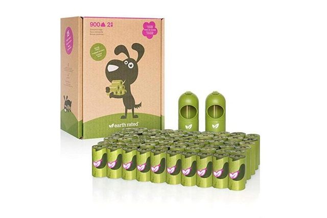 Box displays cartoon dog holding bag, with numerous green bag rolls in front; two green dispensers stand nearby, all set against a white backdrop.