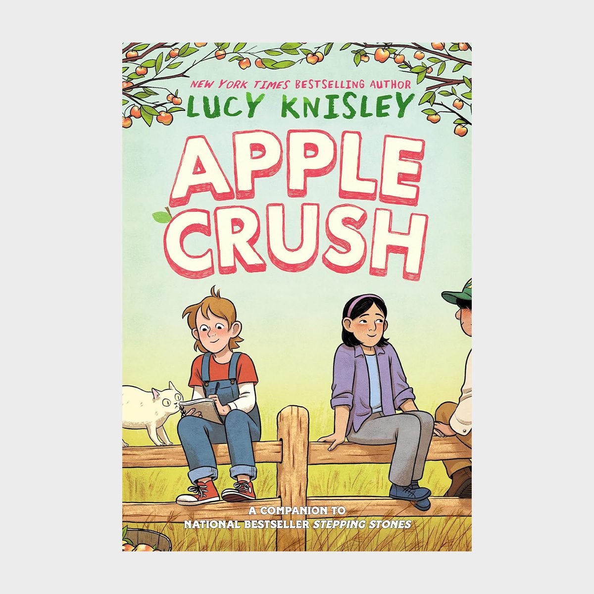 Two children sit on a wooden fence, smiling, with a white goat nearby; greenery and apple branches frame the scene. Text: "Apple Crush" by Lucy Knisley.