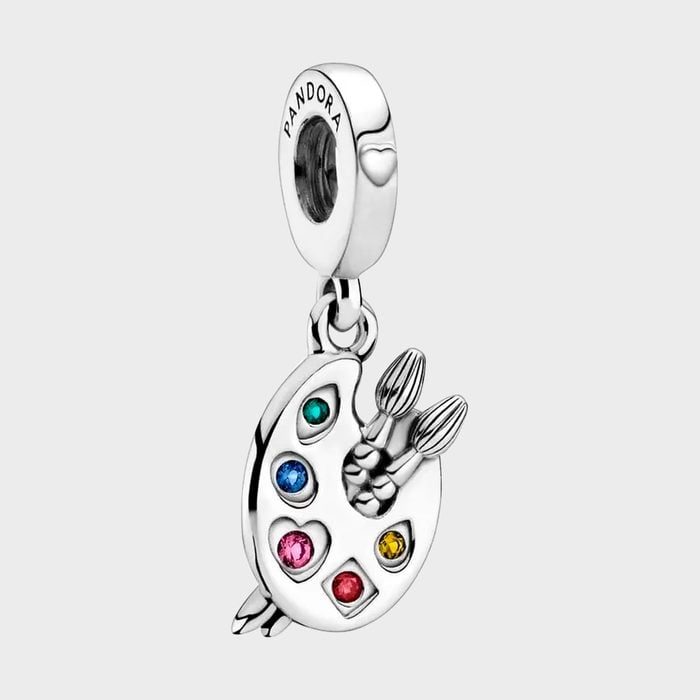 A silver charm displays a painter's palette with colorful stones and brushes, featuring the word 