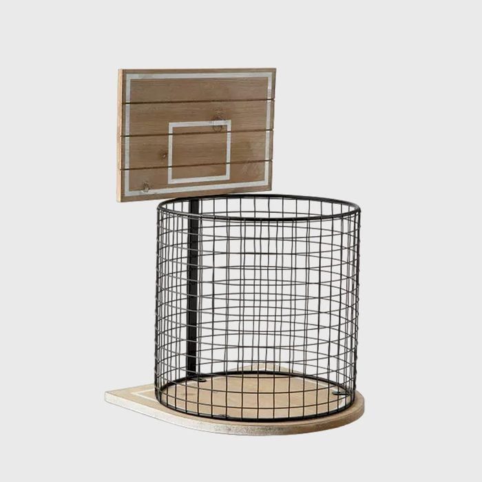 Trash can resembles a basketball hoop, with a wire basket and wooden backboard, positioned against a plain white background.