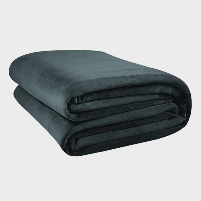 A neatly folded, dark green blanket rests on a plain, light gray background.