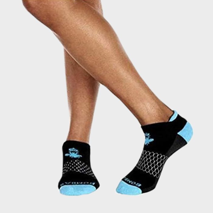 Legs wearing black-and-blue ankle socks stand posed against a plain white background, showcasing the sock's sole and side design.