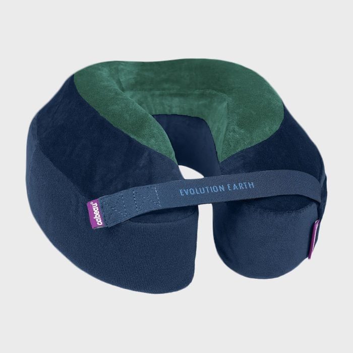 Neck pillow rests on surface; blue and green design; labeled 