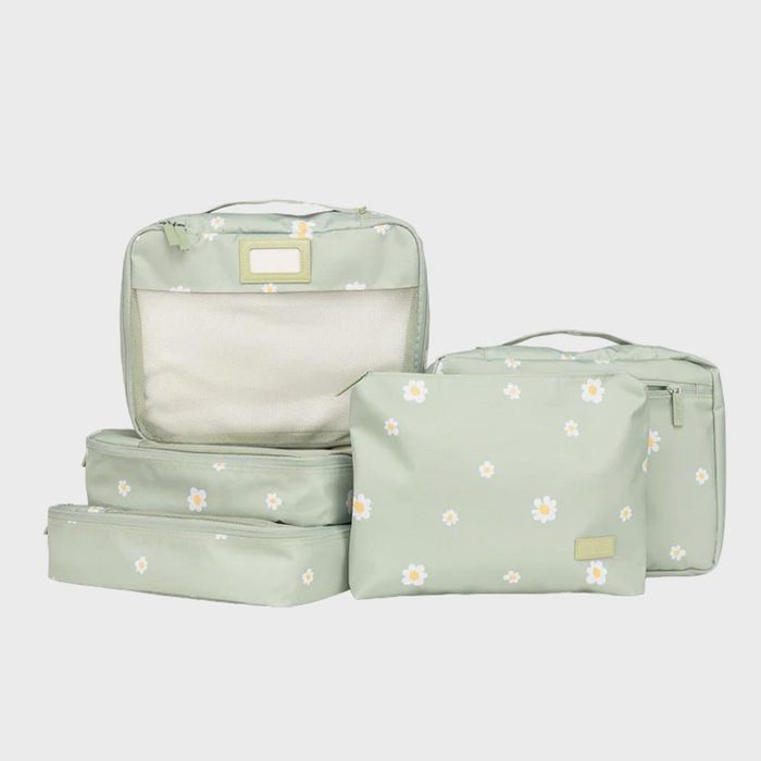 Five light green luggage organizers with white floral patterns sit arranged on a plain background.