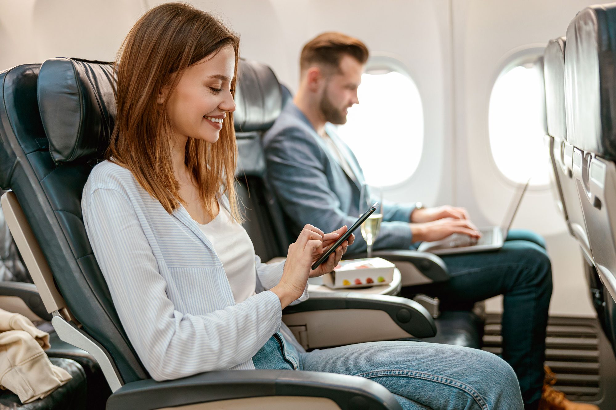 Cheerful Woman Using Mobile Phone In Airplane