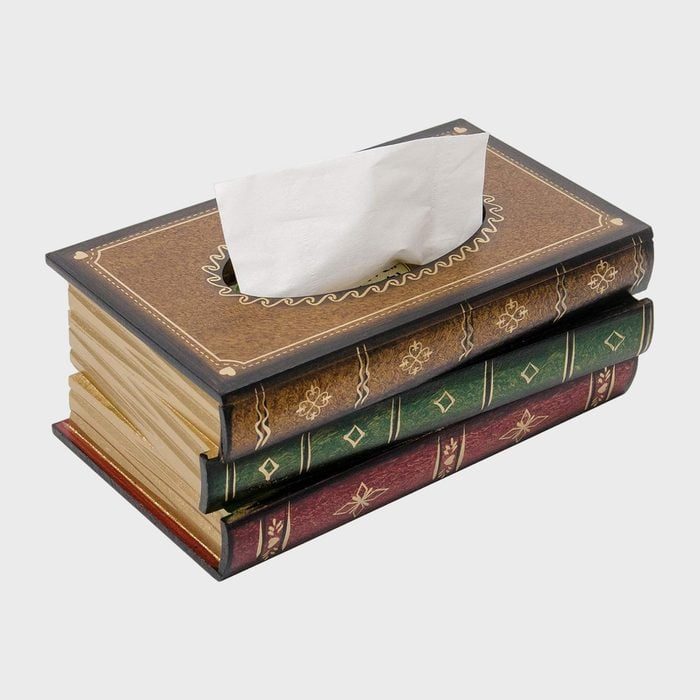 A tissue emerges from a box designed to resemble stacked vintage books, set against a plain background.