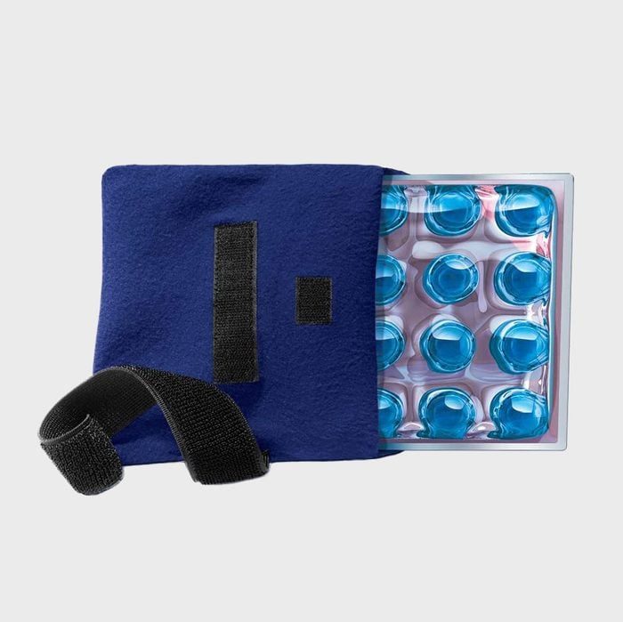Blue gel pack rests inside a fabric cover with a black strap on a gray background.