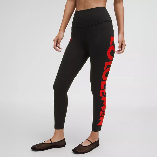 Person standing, wearing black leggings with red 
