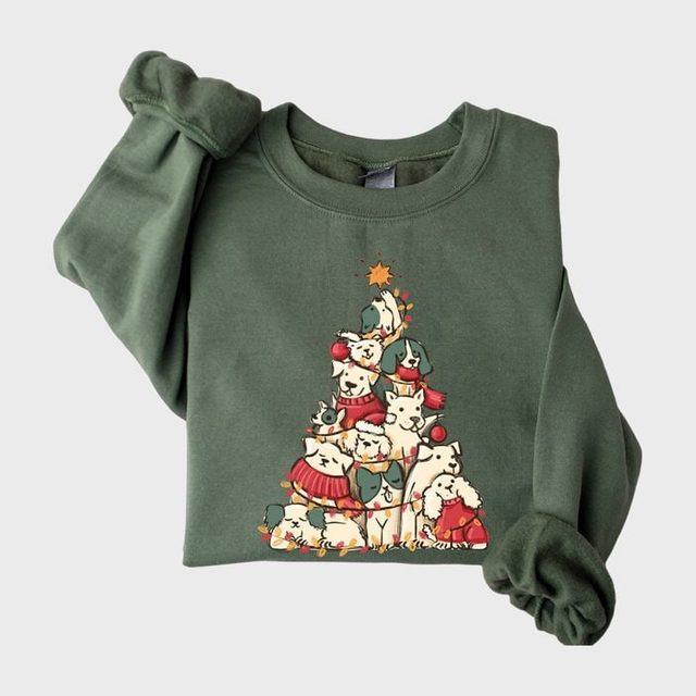 Green sweatshirt features cartoon animals stacked as a Christmas tree, wearing festive attire, with a star on top, creating a holiday theme.