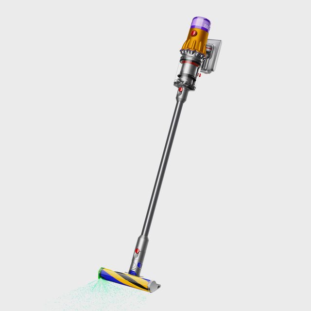 Cordless vacuum standing upright, with a sleek design, emitting green light, against a plain white background.