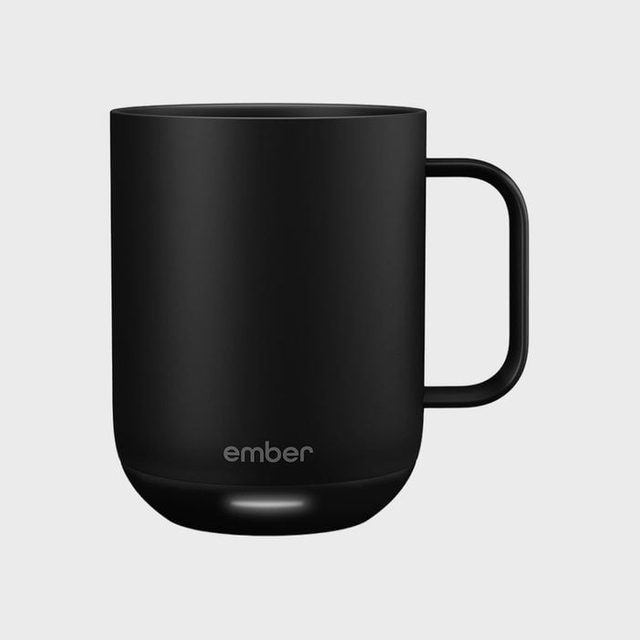 Black mug sits on a plain gray background; the word 