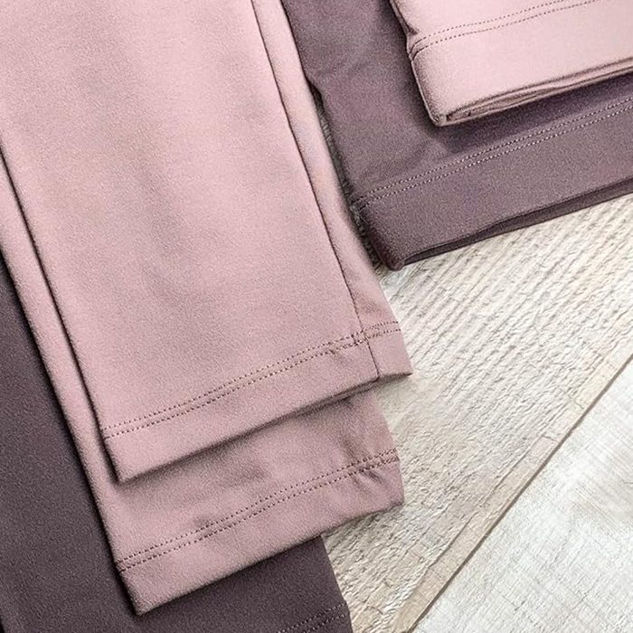 Folded fabric pieces displayed on a wooden surface, highlighting various shades of dusty pink and brown.