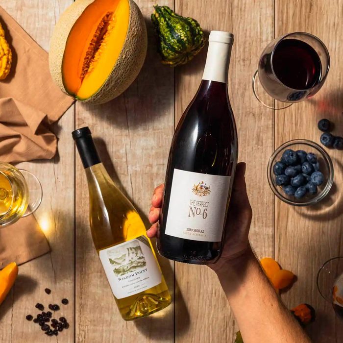 A hand holds a wine bottle labeled 