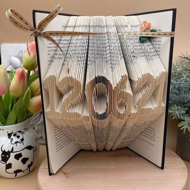 Folded book pages form the date 
