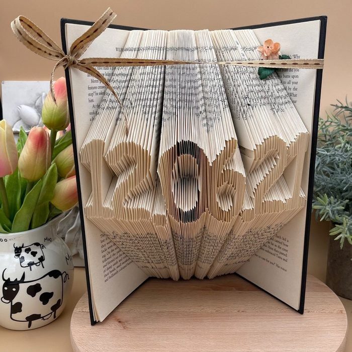 Folded book pages form the date 