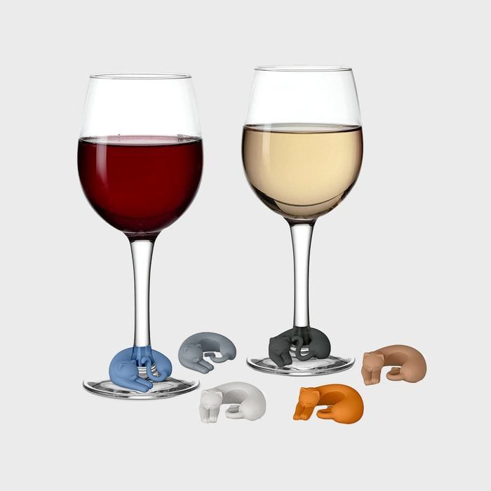 Two wine glasses with colorful cat-shaped charms on stems; additional charms rest around them on a light gray background.
