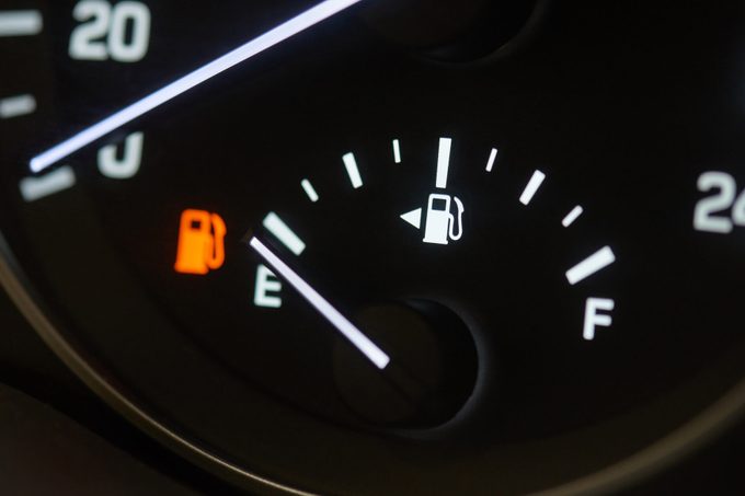 Empty fuel tank indicator close-up on modern car dashboard.