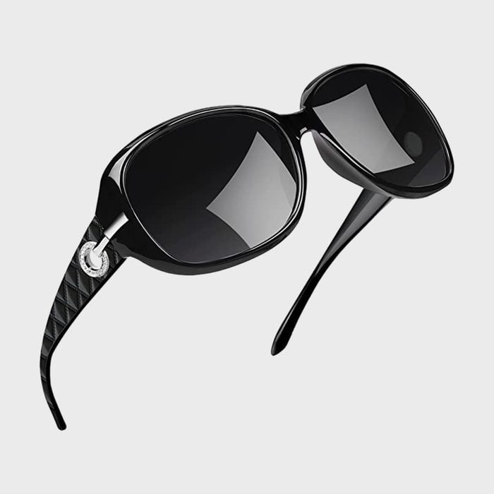 Sunglasses with black, oversized frames and quilted arms rest against a plain white background.