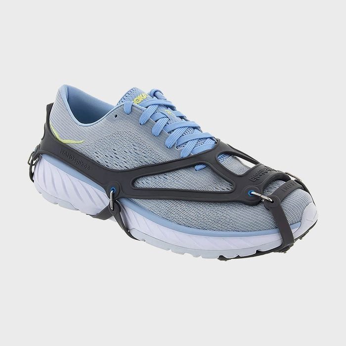 A blue sneaker fitted with a black traction device, set against a white background.