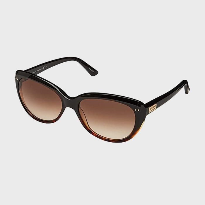 Sunglasses rest on a white surface, featuring a black frame and gradient brown lenses, designed for stylish eye protection in sunny environments.