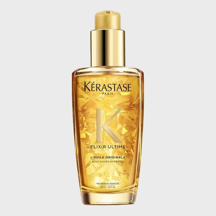 A golden bottle of hair oil stands upright, adorned with intricate geometric patterns, against a plain background. Text: 