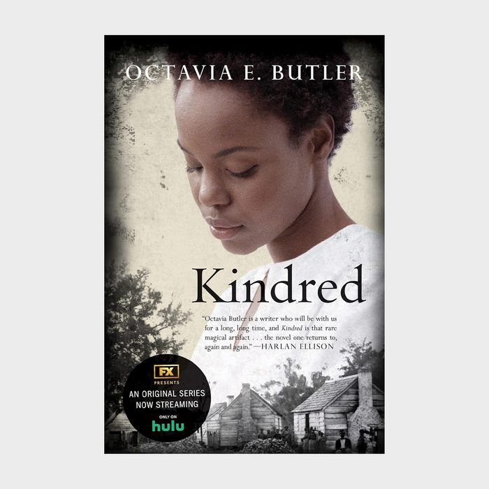 Cover showing woman looking down, with log cabins in the background. Text: 