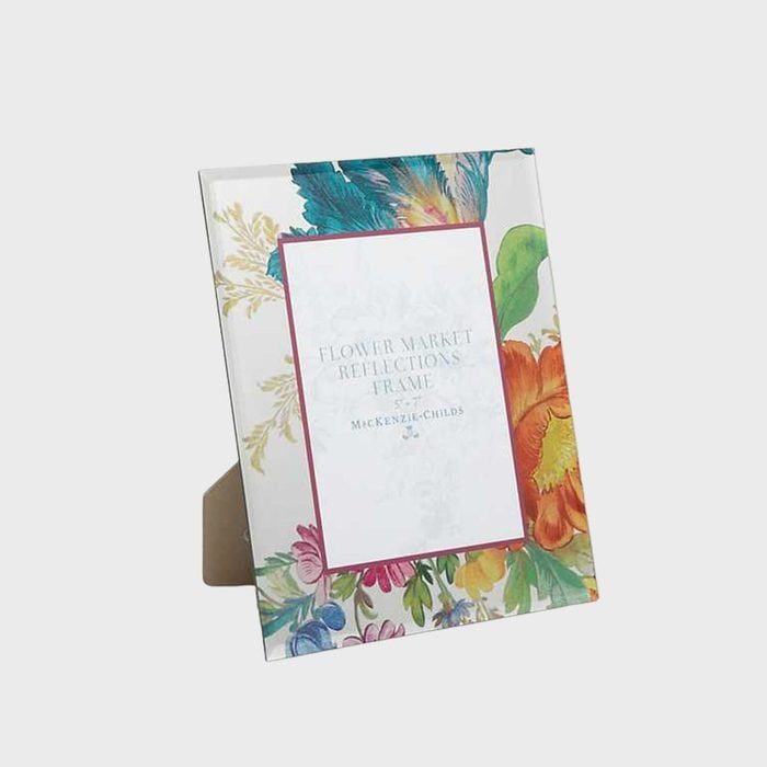 Picture frame displays floral design with bold flowers surrounding white text that reads 